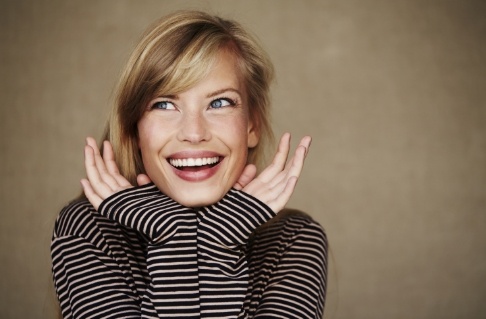 Woman showing off smile after metal free dental restorations