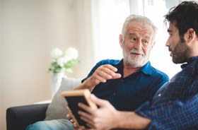 An older man speaking with a younger one