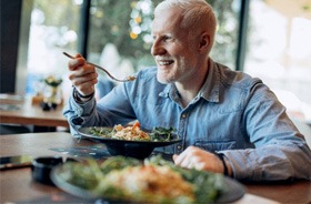 An older man eating a healthy meal in a restaurant