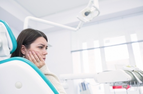 Woman considering the cost of treating dental emergencies