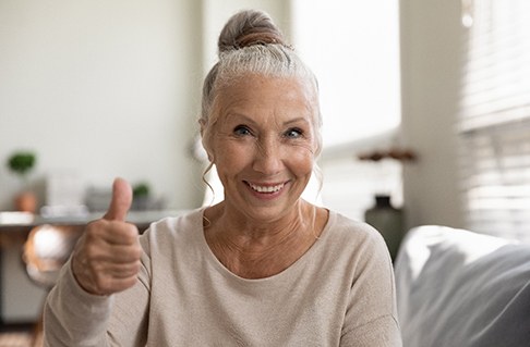 woman smiling after getting dental implants in Framingham