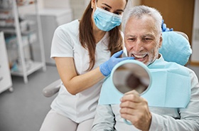 man smiling after getting dental implants in Framingham