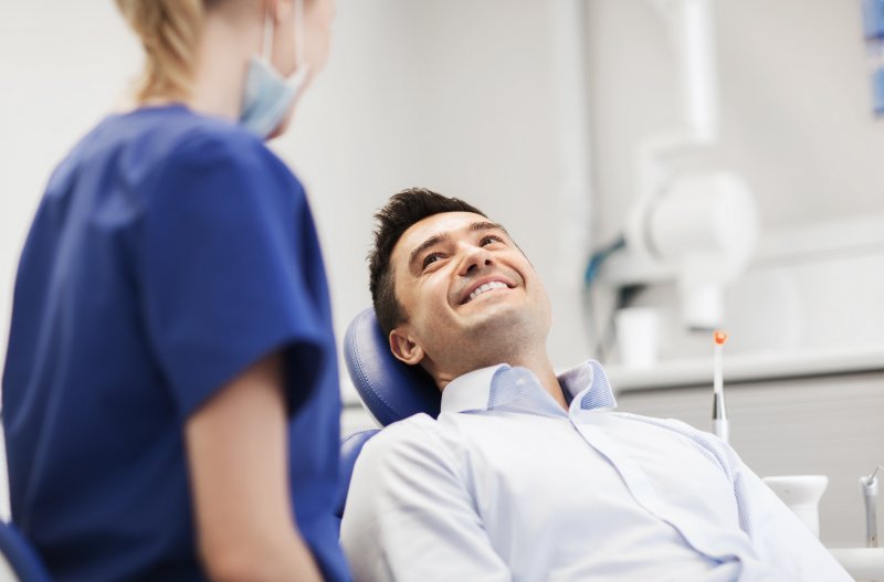 A female dentist chatting with her male patient